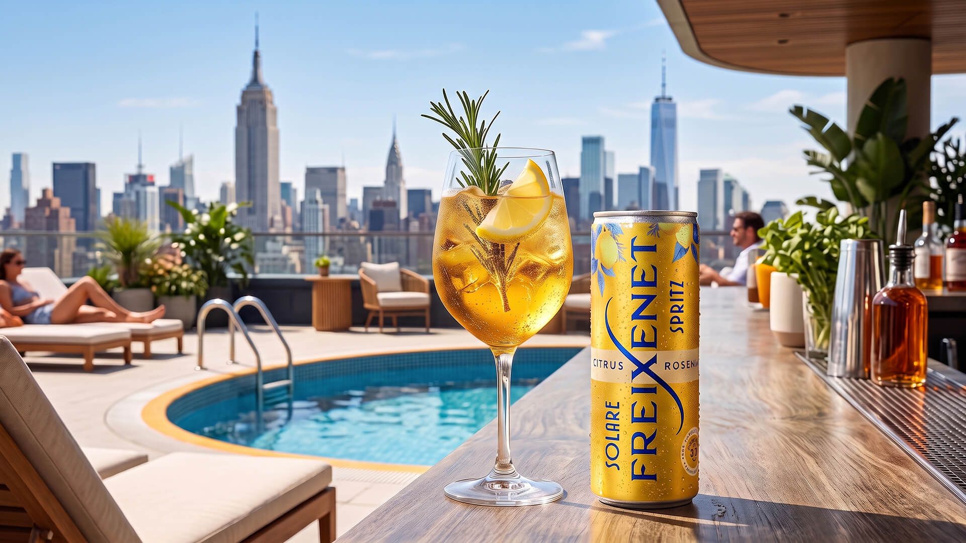 Chilled Freixenet Solare Spritz can and a garnished spritz glass on a rooftop pool bar, Manhattan skyline behind