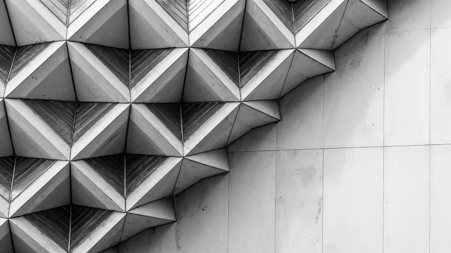 Black-and-white geometric concrete facade, pyramidal relief tiles